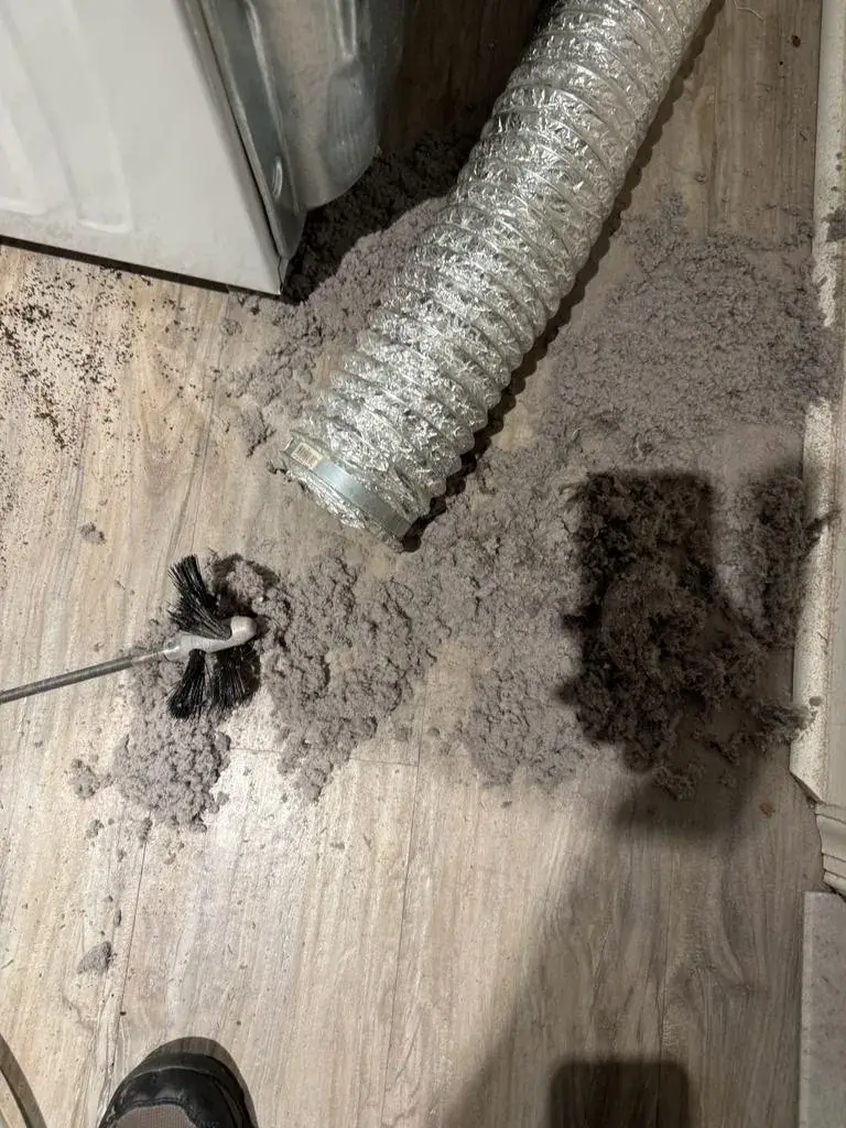 Rotary brush head covered in lint after cleaning a dryer vent line