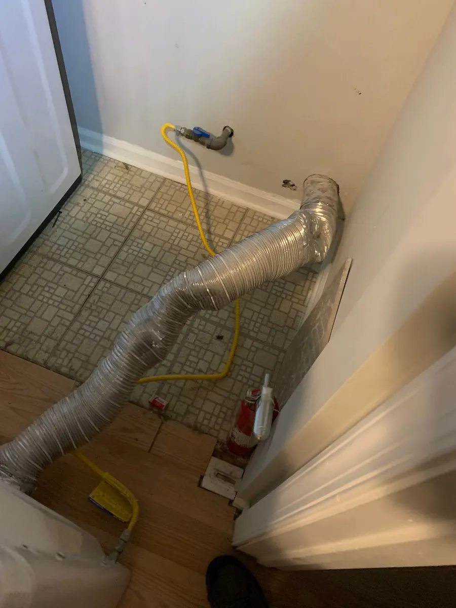 Dryer transition hose and laundry hookup being serviced during a professional dryer vent cleaning