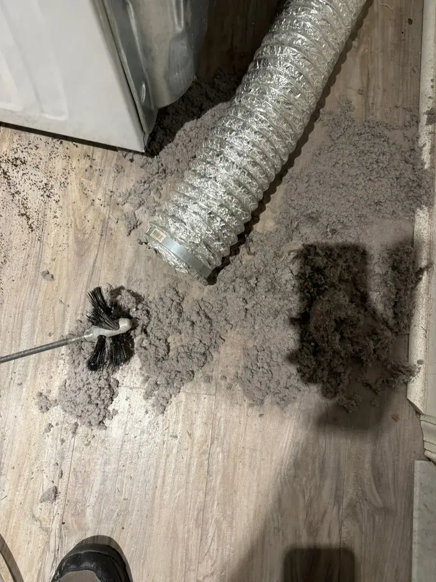 Compacted lint being extracted from a dryer vent line during a cleaning