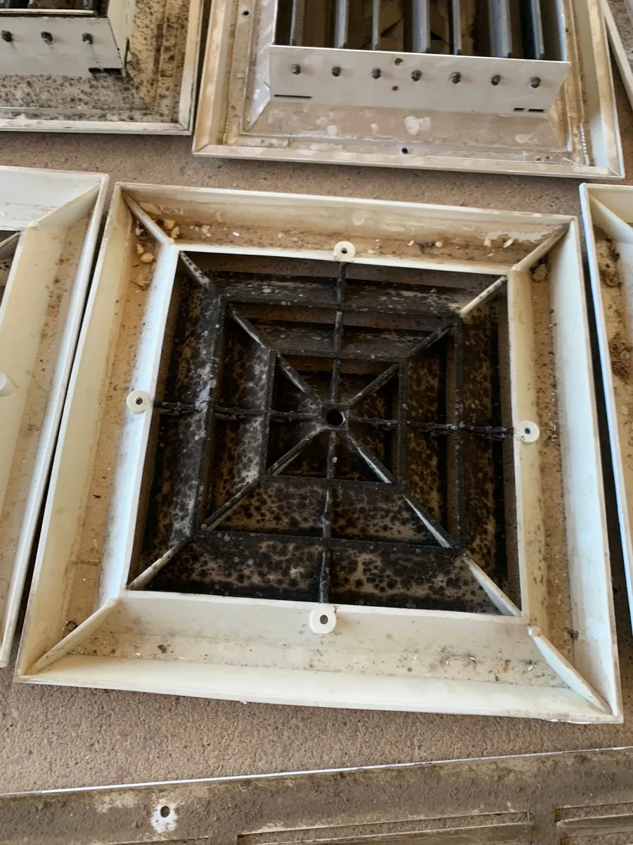 Side-by-side comparison of a heavily soiled air diffuser and a cleaned diffuser